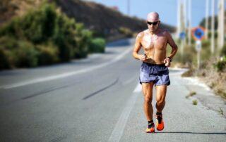 Man over 50 running along road exercising