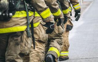 Four firefighters in a row, walking together.