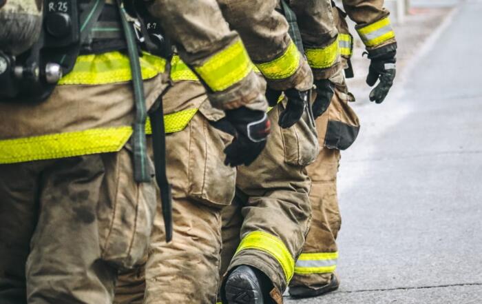 Four firefighters in a row, walking together.