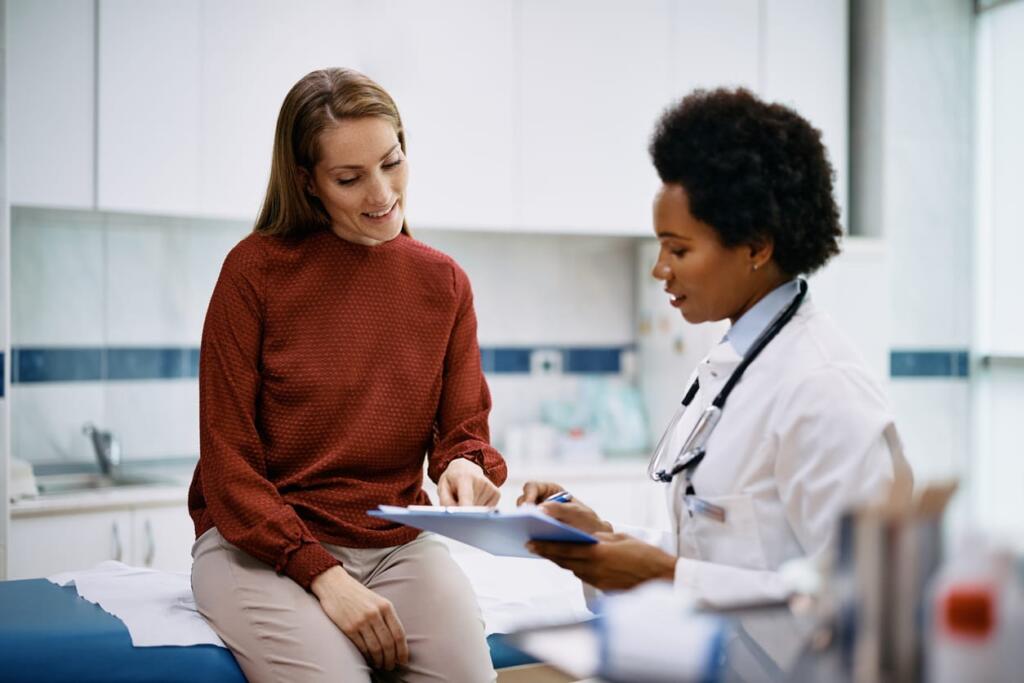 A salon worker speaks with her doctor about a health screening.