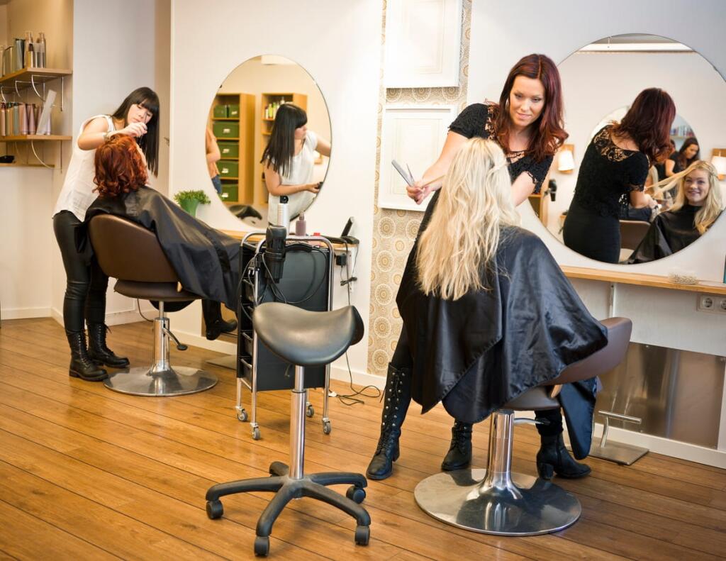 Two salon workers doing client's hair.