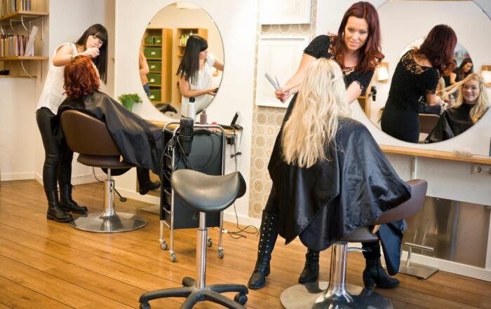 Two salon workers doing client's hair.