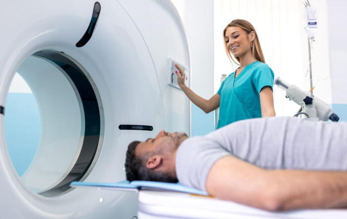 A nurse assisting a patient as he receives a low-dose CT scan.