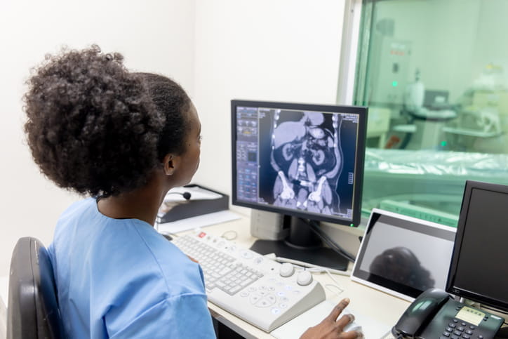 A technician reading the results of a CT scan on her computer. 