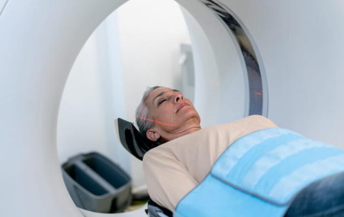 A woman is on a table receiving a CT scan.