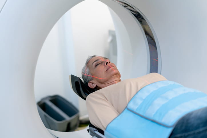 A woman is on a table receiving a CT scan. 