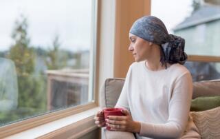 woman with cancer sitting near window