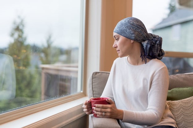 woman with cancer sitting near window