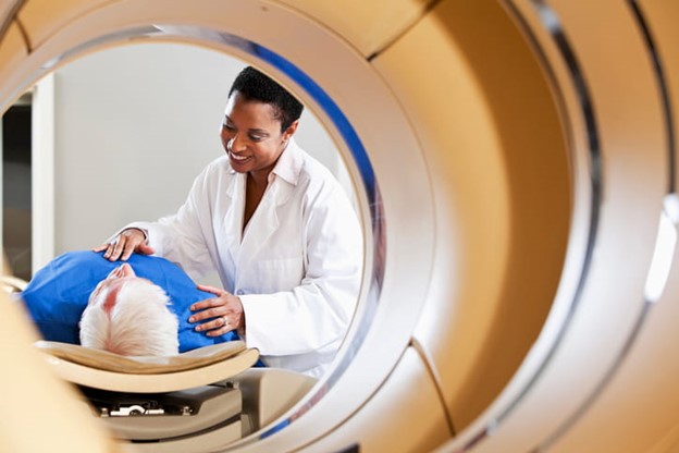 nurse talking to man about to receive CT scan