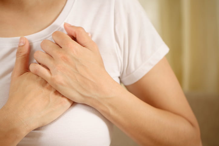 A Woman Who Has Both Hands Placed Over Her Chest Where Her Heart Is. 