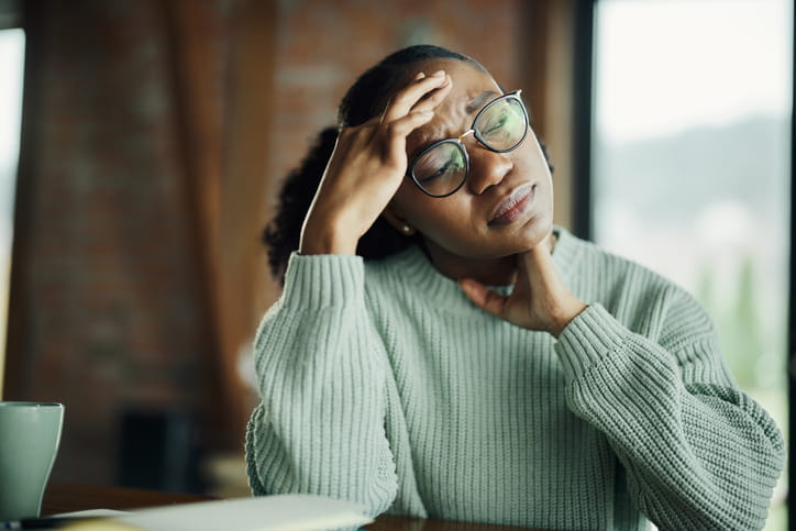 A Woman Overcome With Stress Closing Her Eyes, And Holding Her Head And Neck Due To Tension. 
