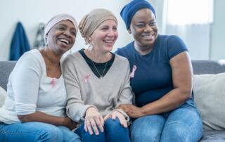 Three Women Who Have Cancer Laugh And Smile Together While Posing For A Photo.