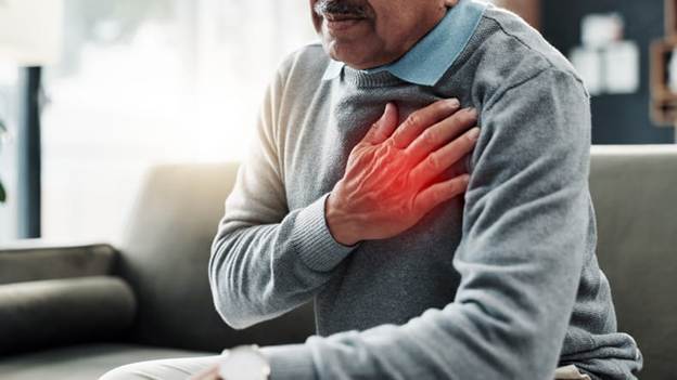 Blog 5 A Man Is Holding His Chest That Radiates Pain Due To A Heart Attack.